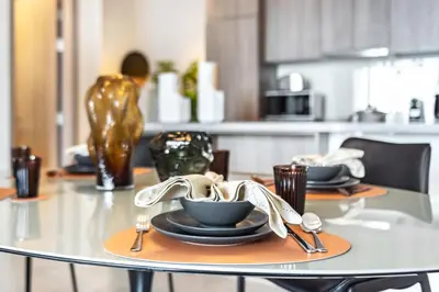 a table with plates and utensils on top of it at The Smart Concierge - Stella Maris in Dubai