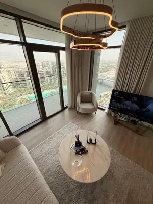 a living room with a table in front of a large window at Palace Dubai Creek Harbour Residences Skyline Apartment in Dubai