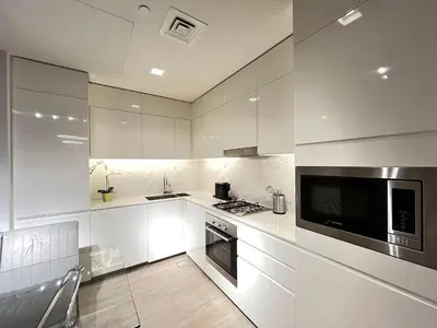 a white kitchen with a stove and a microwave at Palace Dubai Creek Harbour Residences Skyline Apartment in Dubai