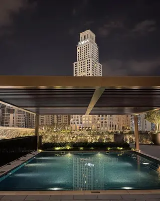 a swimming pool on top of a building at night at Palace Dubai Creek Harbour Residences Skyline Apartment in Dubai