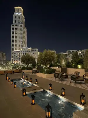 a rooftop pool with a view of a city at night at Palace Dubai Creek Harbour Residences Skyline Apartment in Dubai