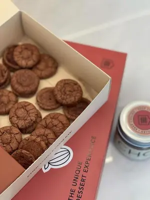 a box of chocolate donuts sitting on a table at Palace Dubai Creek Harbour Residences Skyline Apartment in Dubai