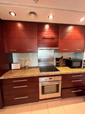 a kitchen with wooden cabinets and a stove top oven at Best Downtown Apartment in Dubai in Dubai
