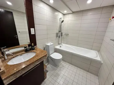 a bathroom with a sink and a tub and a toilet at Best Downtown Apartment in Dubai in Dubai