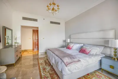 a bedroom with a large bed and a chandelier at Fairmont North 2BR Balcony Sea View in Dubai