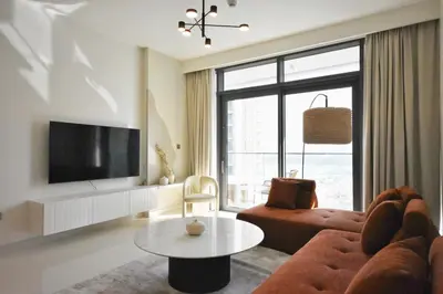a living room with a couch and a tv at Experience Bliss 1BR Haven with Stunning Sea Views - 50AB1 in Dubai