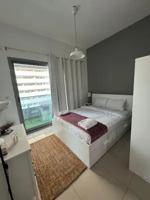 a bedroom with a bed and a large window at Studio Apartment near JBR in Dubai