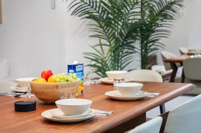 a wooden table with a bowl of fruit on it at Burj Khalifa & Downtown Views - 3BR Family Retreat Near Dubai Mall in Dubai
