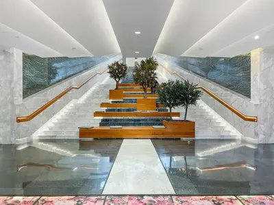 a group of stairs with potted plants in a building at Burj Khalifa & Downtown Views - 3BR Family Retreat Near Dubai Mall in Dubai