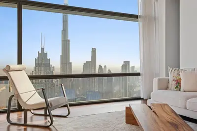 a living room with a white couch and a large window at Burj Khalifa & Downtown Views - 3BR Family Retreat Near Dubai Mall in Dubai