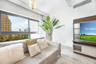 a living room with a couch and a tv at Fairmont North 2BR 2 Balconies Sea View in Dubai