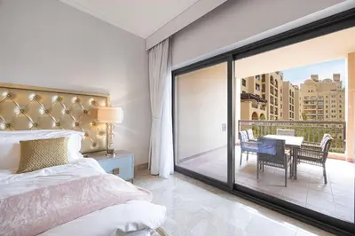 a bedroom with a bed and a balcony with a table at Fairmont North 2BR 2 Balconies Sea View in Dubai