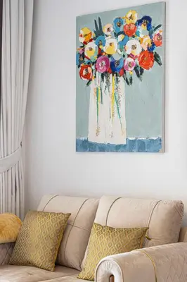 a painting of flowers on a wall above a couch at Fairmont North 2BR 2 Balconies Sea View in Dubai