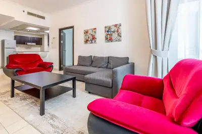 a living room with a couch and red chairs at 1BD apartment in Torch Tower, Dubai Marina in Dubai