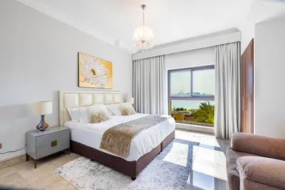a bedroom with a bed and a large window at Fairmont North 2BR Full Sea View in Dubai