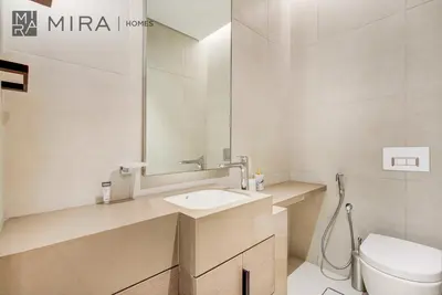 a bathroom with a sink and a toilet and a mirror at Mira Holiday Homes - Lovely 2 BDR with Sea View in Dubai