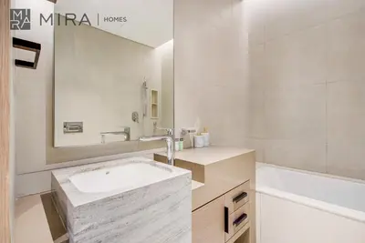 a bathroom with a sink and a tub and a mirror at Mira Holiday Homes - Lovely 2 BDR with Sea View in Dubai