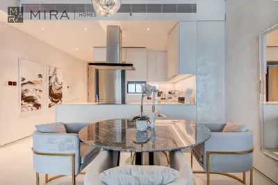a kitchen and dining room with a table and chairs at Mira Holiday Homes - Lovely 2 BDR with Sea View in Dubai