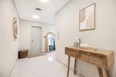 a white room with a table and a mirror at Arabian-Inspired 1BR - Polo Residence Near Burj in Dubai