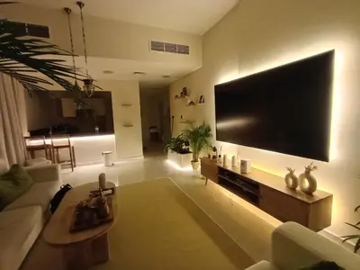 a living room with a large television on the wall at Arabian-Inspired 1BR - Polo Residence Near Burj in Dubai
