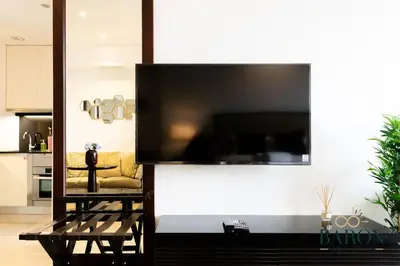 a large flat screen tv on a wall in a living room at The Regal in Dubai