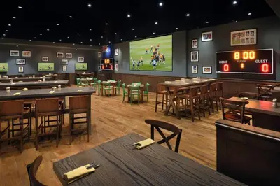 a restaurant with tables and a football game on the screen at The Regal in Dubai