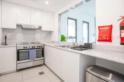 a white kitchen with a stove and a sink at Vacay Lettings 2 Bed Retreat near Burj Al Arab in Dubai