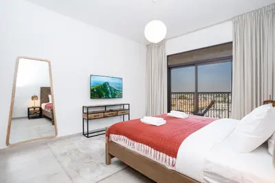 a bedroom with a bed and a large window at Vacay Lettings 2 Bed Retreat near Burj Al Arab in Dubai