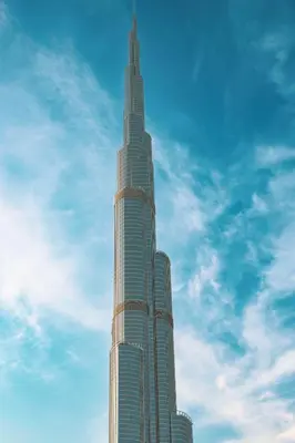 a tall building with a blue sky in the background at Old Town Luxury: 1-BR Apartment with Large Terrace & Burj Khalifa View in Dubai