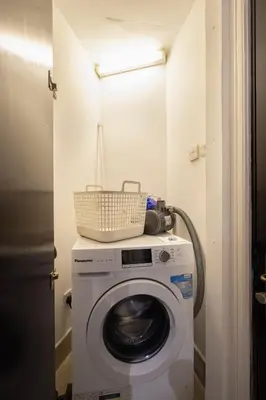 a washing machine with a basket on top of it at Old Town Luxury: 1-BR Apartment with Large Terrace & Burj Khalifa View in Dubai