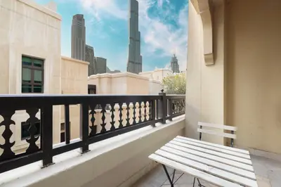 a bench on a balcony with a view of the city at Old Town Luxury: 1-BR Apartment with Large Terrace & Burj Khalifa View in Dubai