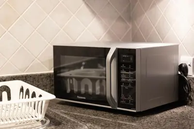 a microwave oven sitting on a counter in a kitchen at Old Town Luxury: 1-BR Apartment with Large Terrace & Burj Khalifa View in Dubai