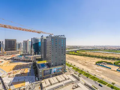 a tall building with a crane in a city at Charming Studio Escape With Unobstructed City View in Dubai