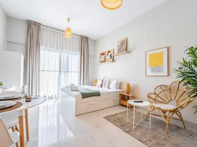 a bedroom with a bed and a table and chairs at Charming Studio Escape With Unobstructed City View in Dubai