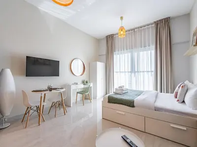 a bedroom with a bed and a table and a dining room at Charming Studio Escape With Unobstructed City View in Dubai