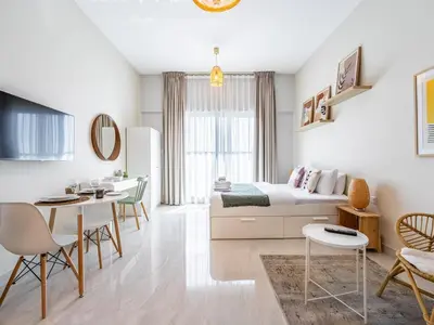 a living room with a bed and a dining room at Charming Studio Escape With Unobstructed City View in Dubai