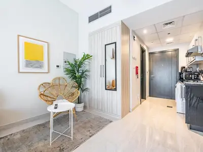 a living room with a table and a chair at Charming Studio Escape With Unobstructed City View in Dubai