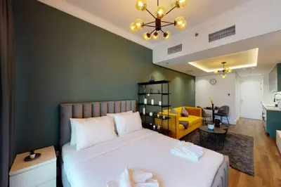 a bedroom with a bed and a living room at Shiny & Fresh - Studio with Lake View - JLT in Dubai