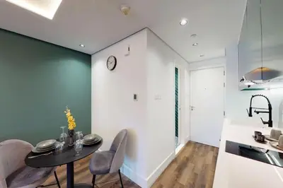 a kitchen and dining room with a table and chairs at Shiny & Fresh - Studio with Lake View - JLT in Dubai