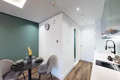 a kitchen and dining room with a table and chairs at Shiny & Fresh - Studio with Lake View - JLT in Dubai