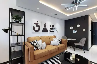 a living room with a brown couch and a table at Earthy & Sharp - Studio with Lake View - JLT in Dubai