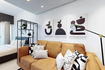 a living room with a couch and a bed at Earthy & Sharp - Studio with Lake View - JLT in Dubai