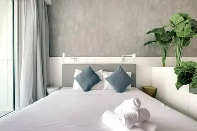 a bedroom with a white bed with towels on it at Bright and cozy - Studio - JLT in Dubai