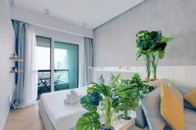 a bedroom with a bed with plants on it at Bright and cozy - Studio - JLT in Dubai