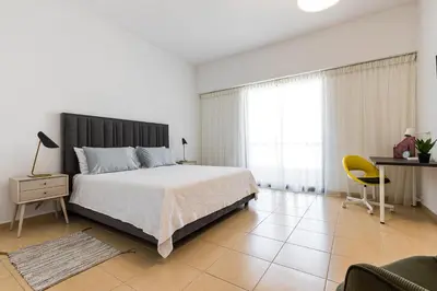 a bedroom with a bed and a desk and a chair at JBR Full Sea View Apartment 1 BR in Dubai