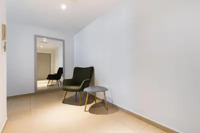 a chair and stool in a room with a mirror at JBR Full Sea View Apartment 1 BR in Dubai