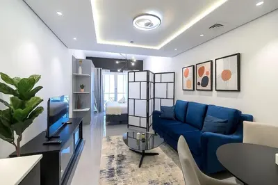 a living room with a blue couch and a table at Classy and Bright - Studio - JLT in Dubai