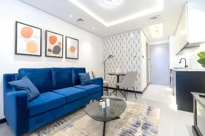 a living room with a blue couch and a table at Classy and Bright - Studio - JLT in Dubai