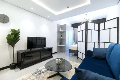 a living room with a blue couch and a fireplace at Classy and Bright - Studio - JLT in Dubai