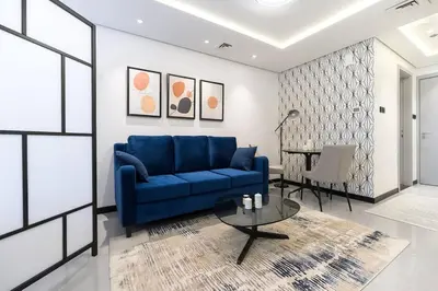 a living room with a blue couch and a table at Classy and Bright - Studio - JLT in Dubai
